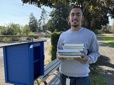 Youth Advisory Council member filling a new Little Free Library to launch Gresham Reads program. 