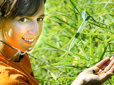 A female scientist in a field of grass with a couple of bugs in her hand. 