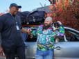 A Gresham employee standing beside a man with his car and dog. They are smiling. 