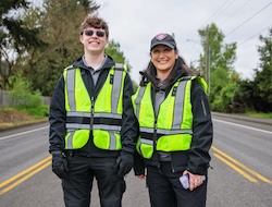 Two community safety specialists out in the field in safety vests.