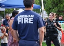 Police officers and firefighters laughing with community members.