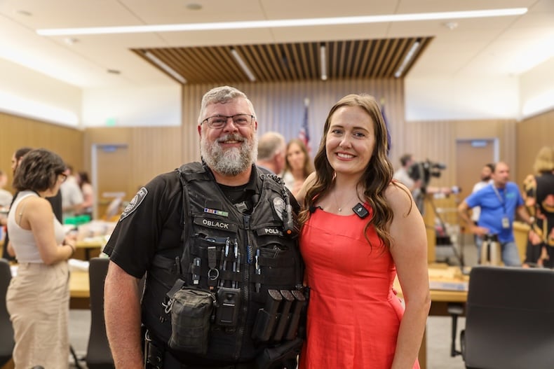 Gresham Police Officer Adam Oblack and DISP graduate Autumn Booth smile for a photo together in the courtroom.