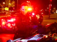 Officer with flashlight at night looking at stolen items on the hood of car during a retail theft mission.