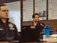 A fire recruit raises his hand to ask a question in the training center classroom.