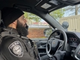 Officer on the phone in a patrol car during a retail theft mission.