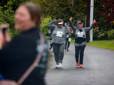 Two seniors wave their hands in excitement as they near the finish line at the Gresham Lilac Run.