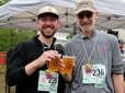 Two men smile and enjoy a post-race celebration beer at the Gresham Lilac Run.