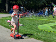 Child riding on scooter in a park. 