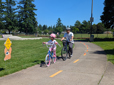 Child and adult riding bikes in the traffic playground at Davis Park.